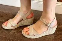A person wearing the Vivaia Round Toe Wedge Sandals
