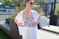 A person standing on a rooftop patio wearing sunglasses and casual attire