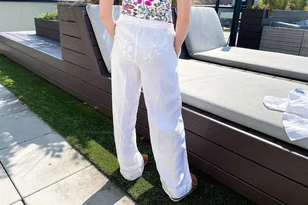 A person standing outdoors near benches in a casual outfit