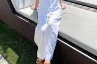 Person sitting on a cushioned bench wearing Tommy Bahama Two Palms High-Rise Linen Easy Pants