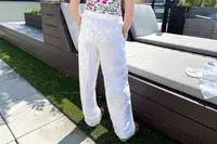 A person standing outdoors near benches in a casual outfit