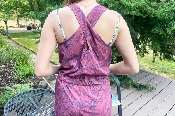 Person wearing a Flylow Tucker Jumpsuit standing outdoors near a wooden deck