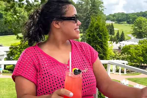 Side profile of a woman wearing a CupShe Crochet Mini Dress while holding a drink