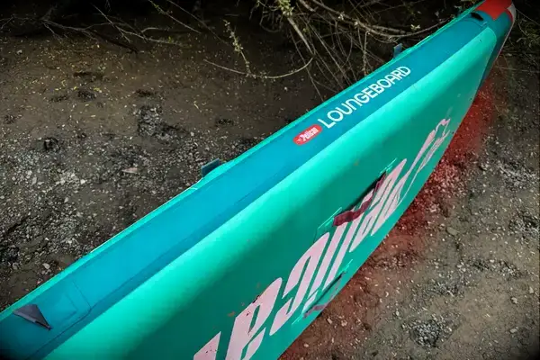 The Atoll 11-foot Inflatable Stand-up Paddle Board deflated on the floor with its accessories