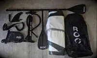 ROC Inflatable Stand-up Paddle Board deflated on a floor with its accessories