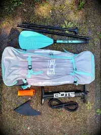 A person and their dog using the SereneLife Inflatable Stand-up Paddleboard on a lake 