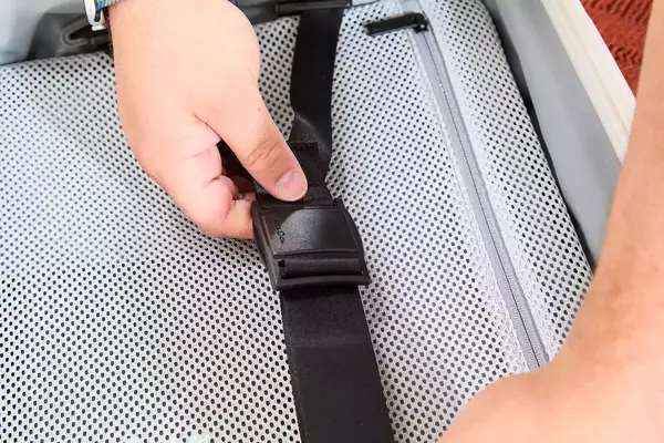 Two hands holding the straps of the Aer Carry-On Max