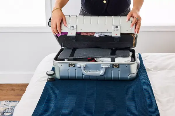 A person closes the Away The Carry-on Aluminum Edition