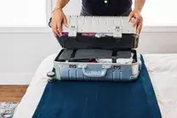 A person closes the Away The Carry-on Aluminum Edition