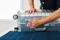 A person secures the latch on the side of the Away The Carry-on Aluminum Edition