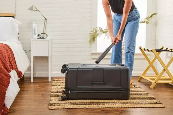 A person hitting the Briggs & Riley Extra Large Trunk Spinner with a bat