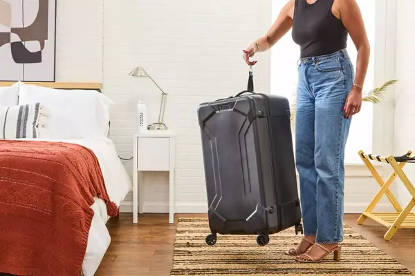 A person holding the scale of the Briggs & Riley Extra Large Trunk Spinner