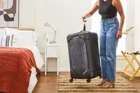 A person holding the scale of the Briggs & Riley Extra Large Trunk Spinner