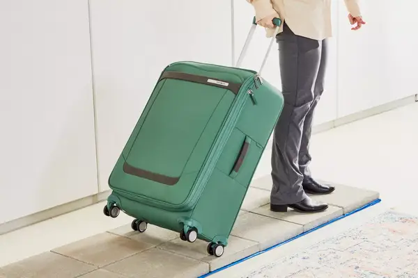 Person rolling the Samsonite Elevation Plus Large Softside Spinner on pavers