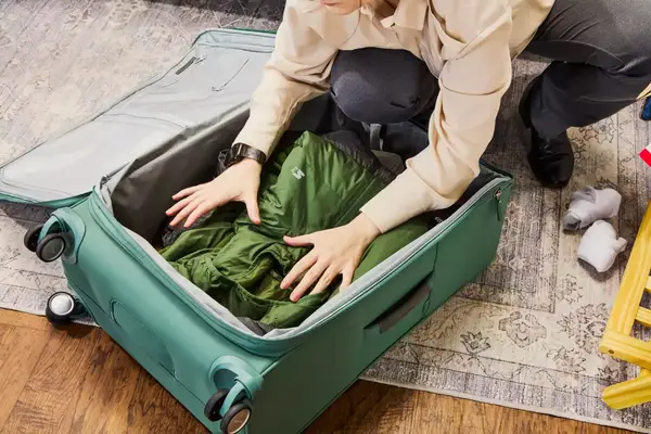 Person packing a jacket into the Samsonite Elevation Plus Large Softside Spinner