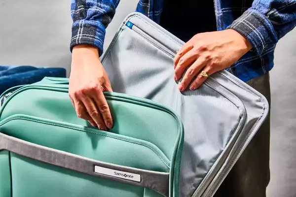 Hands pulling an organizer from the Samsonite Elevation Plus Large Softside Spinner