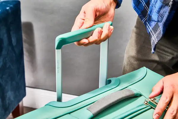 Hand pulling up the handle in the Samsonite Elevation Plus Large Softside Spinner
