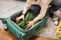 Person packing a jacket into the Samsonite Elevation Plus Large Softside Spinner