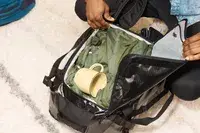 A person wheeling the Dagne Doverr Seattle Carry On Rolling Luggage 20.5