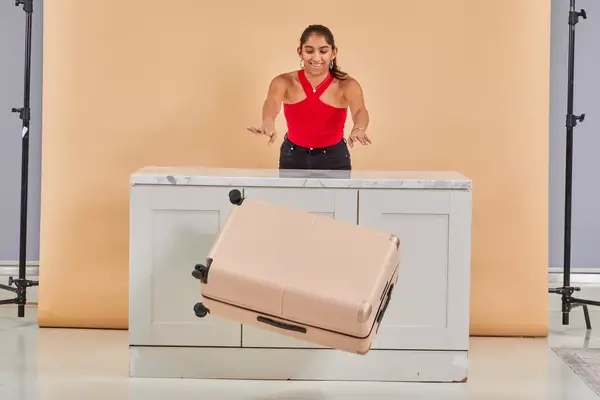 Person pushing the July Checked Plus Large Luggage off a counter