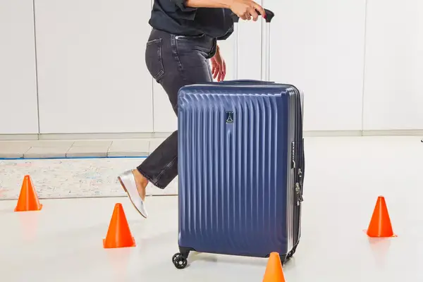 A person walking through cones with the Travelpro Maxlite Air Medium Check-In Hardside Spinner