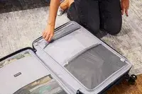 Person zipping a pocket in the Travelpro Maxlite Air Medium Check-In Hardside Spinner
