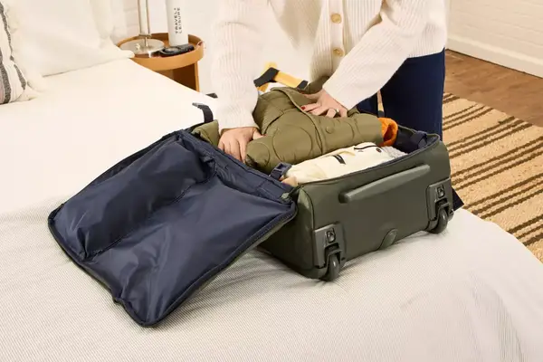 A person places travel items into the Lipault Foldable Plume Cabin