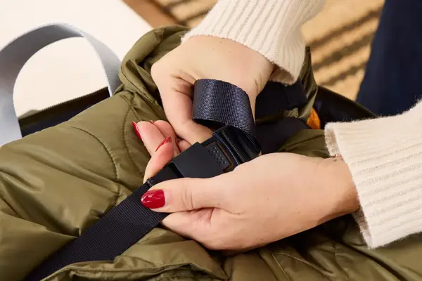 A person secures the strap on the Lipault Foldable Plume Cabin