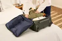 A person places travel items into the Lipault Foldable Plume Cabin