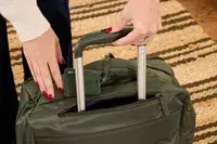 A person lifts up the handle on the Lipault Foldable Plume Cabin