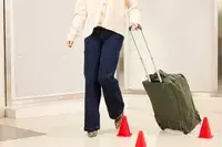 A person wheels the Lipault Foldable Plume Cabin across a floor