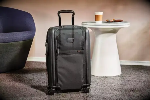 A Tumi suitcase in front of a table