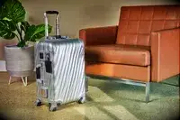 A Tumi carry-on in front of a chair