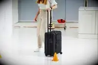 Tumi Alpha Continental Expandable 4 Wheeled Carry-On being wheeled through an orange cone