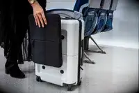 Person using the SnapSleeve of the July Carry On Pro SnapSleeve near airplane seats