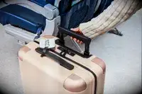 A person rolling a July suitcase on a plane