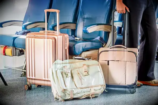 Calpak suitcase, backpack, and underseater on an airplane