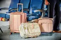 Calpak suitcase, backpack, and underseater on an airplane