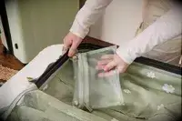 A person places a small zippered bag into the Calpak Evry Starter Bundle