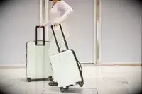 A person wheels the Calpak Evry Starter Bundle over paving stones