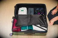 A person packing the Calpak Hue Trunk