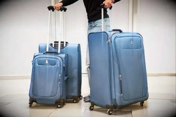 A person wheels the Travelpro Maxlite 5 Floating On Air Luggage set over paving stones