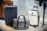 A variety of three Travelpro suitcases and bags on the floor