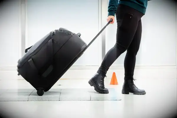 A person rolling a Briggs & Riley duffel with wheels