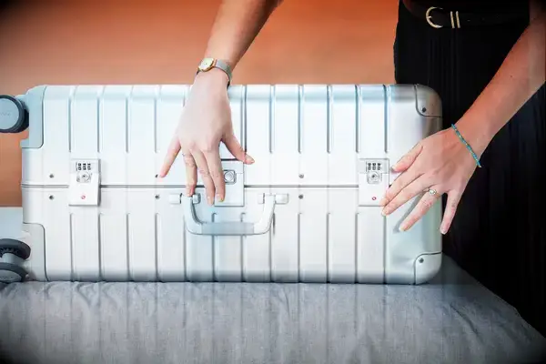 A person packing an Away Suitcase