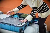 A person packing the Away Medium suitcase