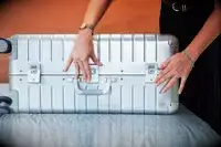 A person packing an Away Suitcase