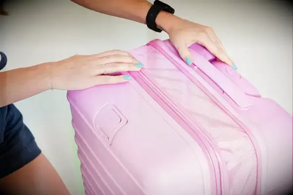 Person expanding a Beis suitcase