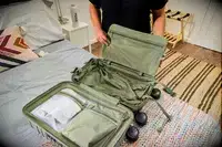 A person places a laptop pouch into the Béis The Small Carry-on Roller