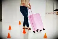 Person rolling a checked suitcase